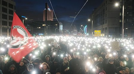Teilnehmer einer Kundgebung versammeln sich auf dem Johannisplatz und leuchten mit den Taschenlampen ihrer Telefone. / Foto: Sebastian Willnow/dpa
