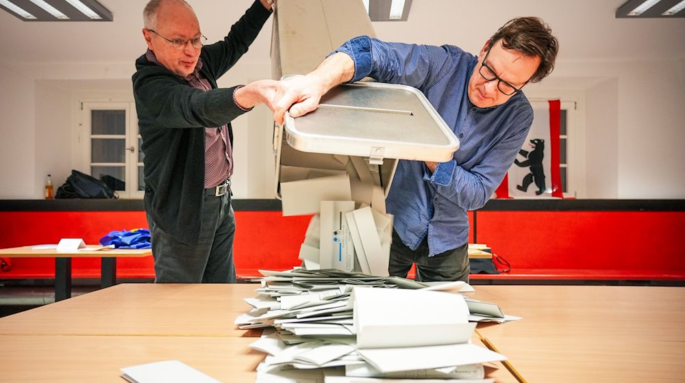 Wahlhelfer leeren bei der Stimmauszählung im Carl von Ossietzky-Gymnasium im Wahllokal 317 die Wahlurnen aus. / Foto: Soeren Stache/dpa