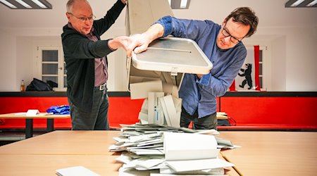 Poll workers empty the ballot boxes at polling station 317 in the Carl von Ossietzky-Gymnasium during the vote count / Photo: Soeren Stache/dpa