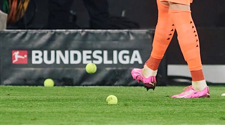 Dortmunds Torwart schießt Tennisbälle vom Platz, die Fans aus Protest auf das Spielfeld geworfen haben. / Foto: Bernd Thissen/dpa