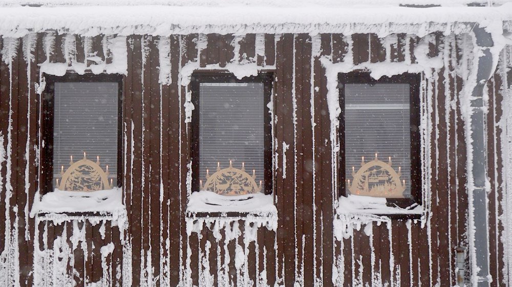 Schwibbogen stehen in den Fenstern eines Gebäudes auf dem Fichtelberg. / Foto: Sebastian Willnow/dpa