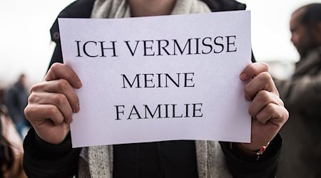 Ein Mitglied des Flüchtlingsrats hält ein Schild mit der Aufschrift «Ich vermisse meine Familie» in den Händen. / Foto: Sophia Kembowski/dpa/Archivbild