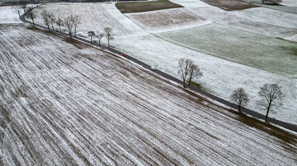 Cars drive along a road in the lightly snow-covered Ore Mountains / Photo: Jan Woitas/dpa