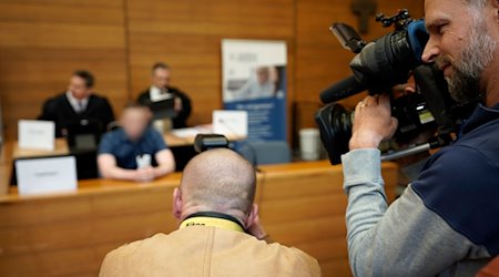 Medienvertreter filmen den Angeklagten (Hintergrund Mitte) im Landgericht Traunstein. / Foto: Uwe Lein/dpa/Archivbild