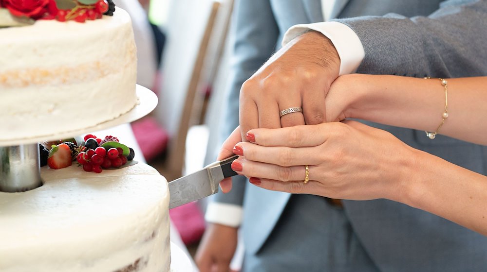 Наречений і наречена розрізають весільний торт під час весільної церемонії / Фото: Silas Stein/dpa/Illustration