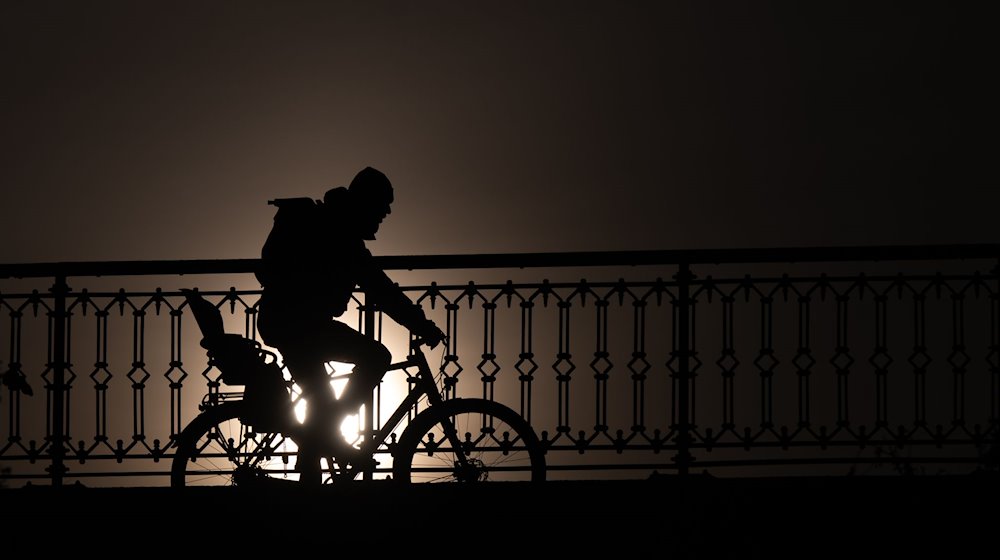 Ein Radfahrer ist am Vormittag bei Sonnenschein auf der Marienbrücke unterwegs. / Foto: Robert Michael/dpa/Symbolbild