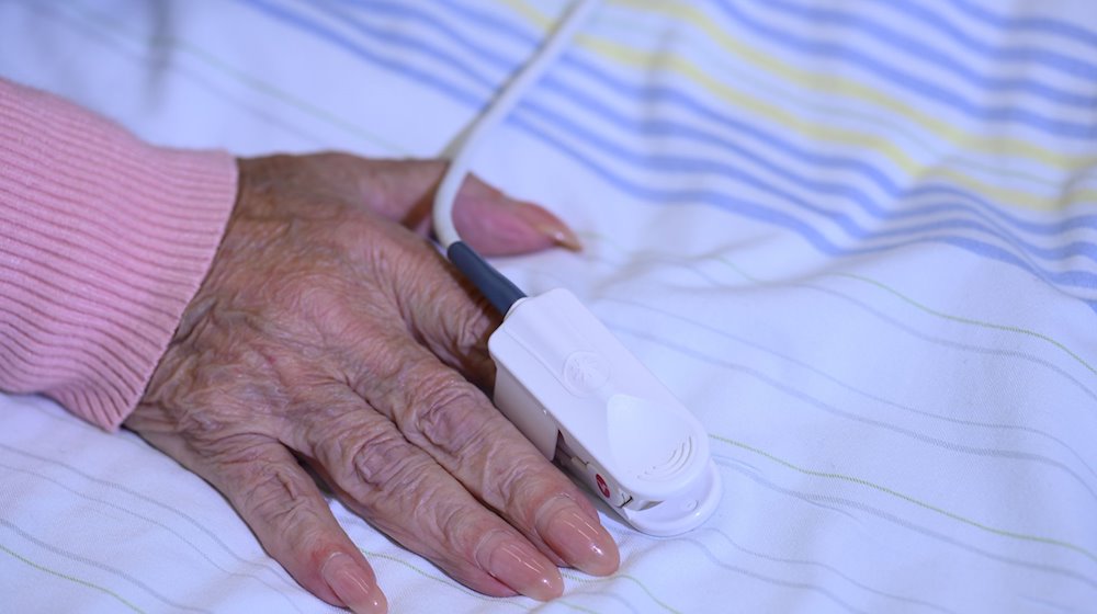 Пацієнтка у відділенні гострої геріатрії в Університетській лікарні Дрездена має на пальці вимірювач кисню в крові. / Фото: Robert Michael/dpa
