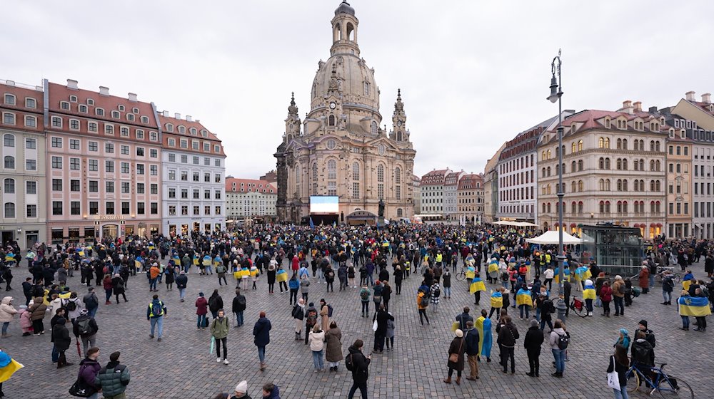 Teilnehmer einer Friedenskundgebung stehen auf dem Neumarkt vor der Frauenkirche. / Foto: Sebastian Kahnert/dpa/Archivbild