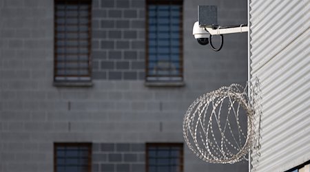 Eine Videoüberwachung und Stacheldraht sind im Hof der Justizvollzugsanstalt Dresden. / Foto: Robert Michael/dpa