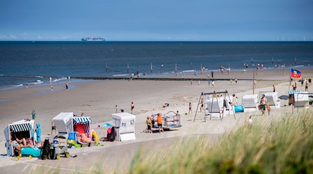 Zahlreiche Touristen sitzen bei sonnigem Wetter in Strandkörben am Strand der Insel Wangerooge. / Foto: Hauke-Christian Dittrich/dpa/Archivbild