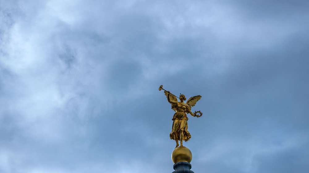 Wolken ziehen über der goldenen Fama-Skulptur auf der Kuppel der Hochschule für Bildende Künste (HfBK). / Foto: Jens Büttner/dpa-Zentralbild/dpa