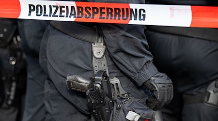 Polizisten stehen hinter einem Polizei-Flatterband. / Foto: Hannes P. Albert/dpa/Symbolbild