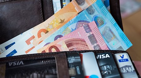 Banknoten und Bankkarten liegen in einer Geldbörse. / Foto: Monika Skolimowska/zb/dpa/Archivbild