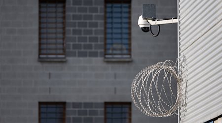 Eine Videoüberwachungsgerät und Stacheldraht sind im Hof der JVA Dresden an einem Gebäude montiert. / Foto: Robert Michael/dpa/Symbolbild