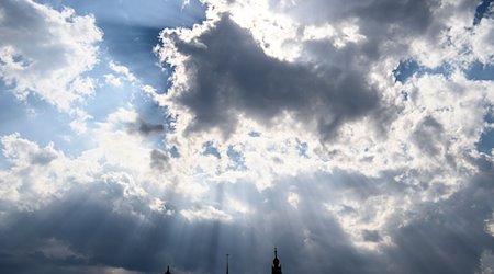 Sonnenstrahlen leuchten durch die Wolken auf die Altstadtkulisse mit dem Ständehaus (l-r), dem Georgentor, dem Hausmannsturm und der Hofkirche. / Foto: Robert Michael/dpa-Zentralbild/dpa