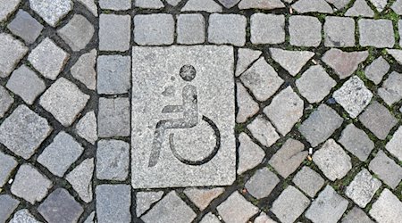 Die Kennzeichnung eines Behindertenparkplatzes ist in der Innenstadt in das Straßenpflaster integriert. / Foto: Jens Kalaene/dpa-Zentralbild/dpa