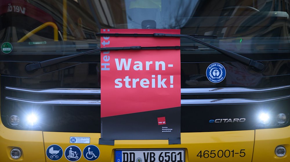 A "warning strike" poster is stuck under the windshield wiper on a DVB bus at the Trachenberge depot / Photo: Robert Michael/dpa