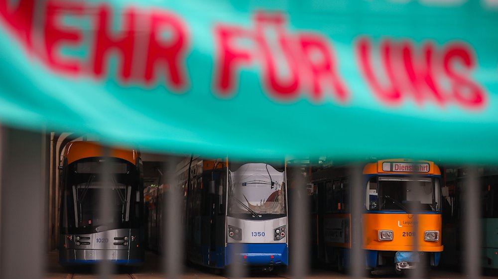 Straßenbahnen stehen während eines Warnstreiks hinter einem verschlossenen Tor im Straßenbahnhof Angerbrücke. / Foto: Jan Woitas/dpa