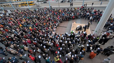 Menschen treffen sich am Gedenktag zum gemeinsamen Singen vor dem Dresdner Kulturpalast. / Foto: Matthias Rietschel/dpa-Zentralbild/dpa