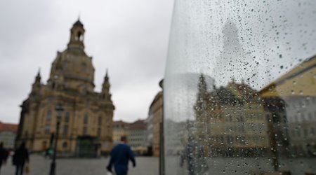 Eine Scheibe eines Restaurants auf dem Neumarkt vor der Frauenkirche ist mit Regentropfen benetzt. / Foto: Robert Michael/dpa-Zentralbild/dpa