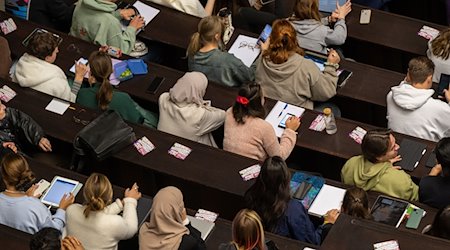 Studierende nehmen an der Einführungveranstaltung im Audimax der Ludwig-Maximilians-Universität (LMU) teil. / Foto: Peter Kneffel/dpa