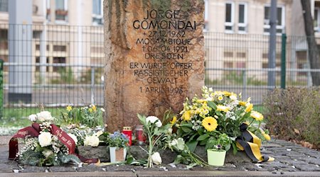 Flowers and candles lie or stand in front of a memorial stone for the Mozambican Jorge Gomondai / Photo: Sebastian Kahnert/dpa-Zentralbild/dpa