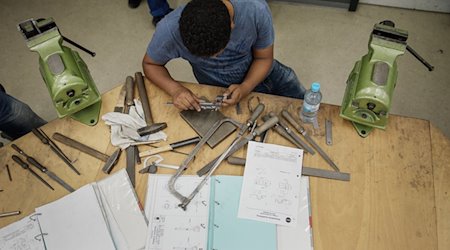 A refugee from Eritrea sits at his workbench and measures a workpiece / Photo: Andreas Arnold/dpa/Symbolic image
