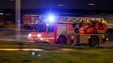 Ein Fahrzeug der Feuerwehr mit Drehleiter fährt mit Blaulicht und Martinshorn am Morgen durch die Stadt. / Foto: Jan Woitas/dpa