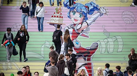 Besucher gehen über eine Treppe mit einem Manga-Motiv zum 10. Jubiläum der Manga-Comic-Con auf der Leipziger Buchmesse. / Foto: Jan Woitas/dpa