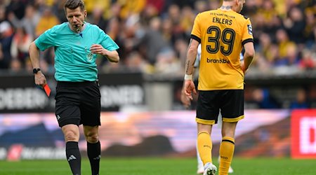 Referee Patrick Ittrich (l) shows Dynamo's Kevin Ehlers the red card. / Photo: Robert Michael/dpa
