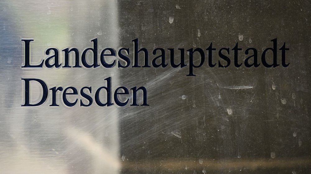 A sign for the state capital Dresden is mounted next to the entrance to the town hall / Photo: Robert Michael/dpa