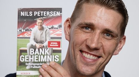 Нільс Петерсен, колишній гравець Бундесліги, представляє свою книгу "Bankgeheimnis" на Лейпцизькому книжковому ярмарку / Фото: Hendrik Schmidt/dpa