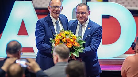 Tino Chrupalla (r), Bundesvorsitzender, gratuliert Jörg Urban (beide AfD), sächsischer Landesvorsitzender, nach seiner Wahl zum Spitzenkandidaten auf dem Landesparteitag der AfD. / Foto: Jan Woitas/dpa