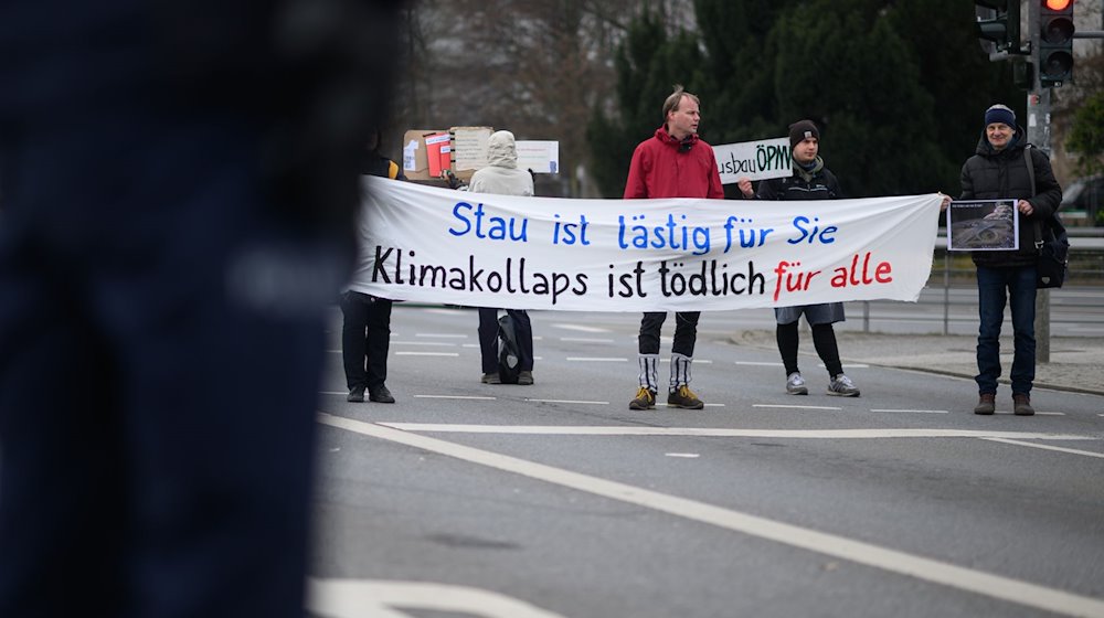 مشاركون في عملية عرقلة لعربة عمل لنشطاء المناخ في مكان فريتز فورستر بلاتز في دريسدن. / صورة: روبرت مايكل / دبليو.الألمانية