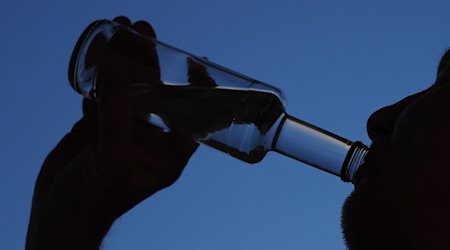 Ein Mann trinkt am Abend aus einer kleinen Flasche Schnaps. Am Dienstag wird der 4. Sächsische Drogen- und Suchtbericht vorgestellt. / Foto: Soeren Stache/dpa-Zentralbild/dpa