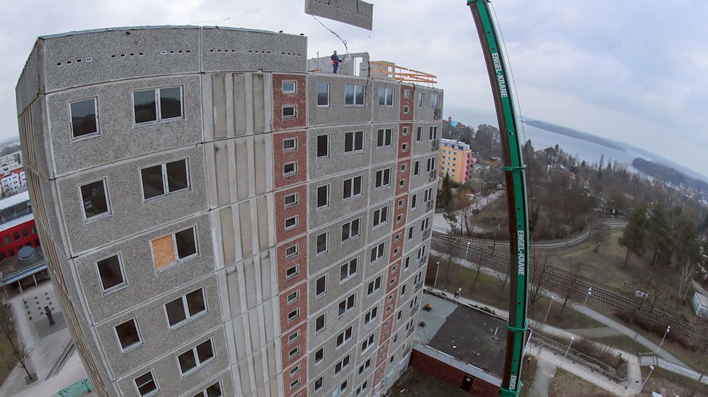 A mobile crane is used to dismantle the high-rise buildings in the Neu Zippendorf district, which were built during the GDR era, slab by slab / Photo: Jens Büttner/dpa-Zentralbild/dpa