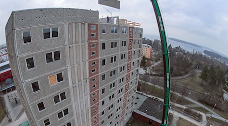 Mit einem Mobilkran werden die zu DDR-Zeiten errichteten Hochhäuser im Stadtteil Neu Zippendorf Platte für Platte abgebaut. / Foto: Jens Büttner/dpa-Zentralbild/dpa