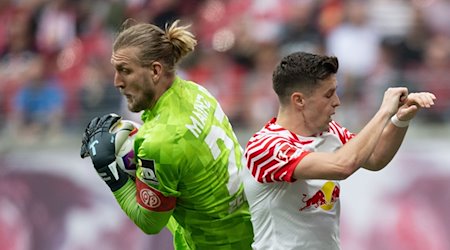 Leipzigs Christoph Baumgartner (r) und der Mainzer Torhüter Robin Zentner kämpfen um den Ball. / Foto: Hendrik Schmidt/dpa