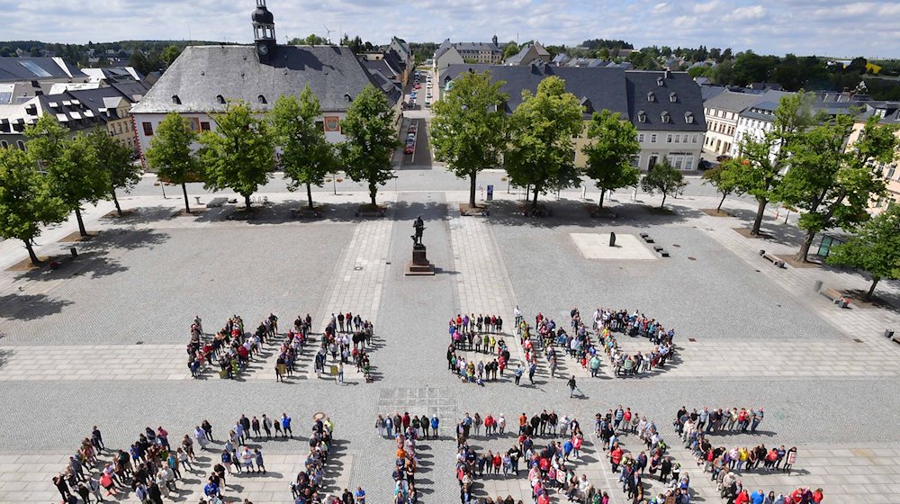 Pupils from Marienberg Grammar School and citizens of the town form the "We are World Heritage" sign. / Photo: Wolfgang Schmidt/dpa-Zentralbild/dpa/Archivbild