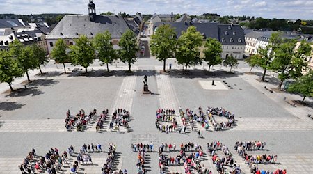 Pupils from Marienberg Grammar School and citizens of the town form the "We are World Heritage" sign. / Photo: Wolfgang Schmidt/dpa-Zentralbild/dpa/Archivbild