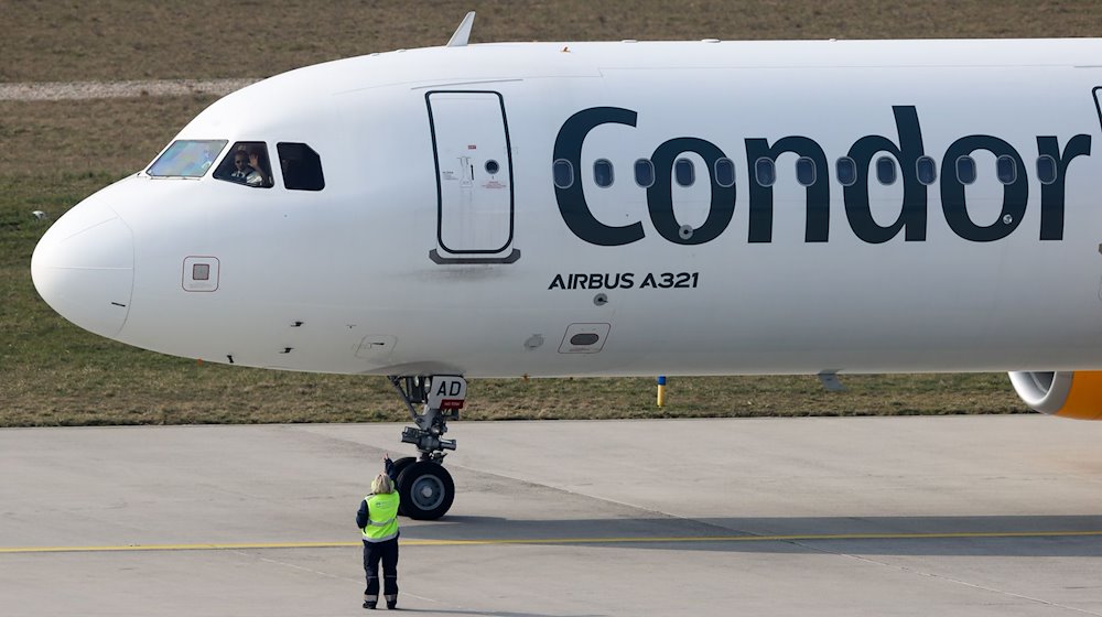 The pilot of a Condor plane bound for Tenerife waves to the ground crew before take-off from Leipzig/Halle Airport / Photo: Jan Woitas/dpa-Zentralbild/dpa