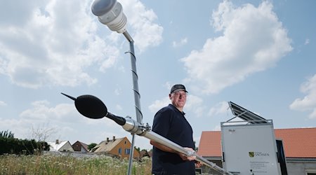 Jörg Puchmüller, Fluglärmschutzbeauftragter des Landes Sachsen, an einer mobilen Messstation für Fluglärm. / Foto: Sebastian Willnow/dpa