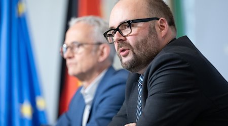 Christian Piwarz (CDU, derecha), Ministro de Cultura de Sajonia, habla en una rueda de prensa del gabinete / Foto: Sebastian Kahnert/dpa
