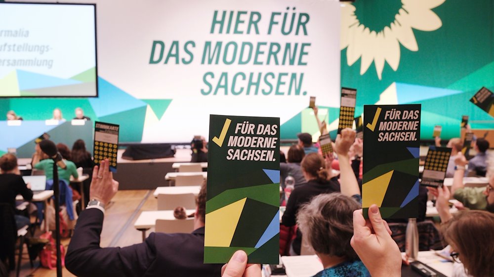 Voting cards are held aloft. The occasion is the state election meeting of Bündnis 90/ Die Grünen Sachsen, at which the list places for the upcoming state elections will be elected. / Photo: Sebastian Willnow/dpa