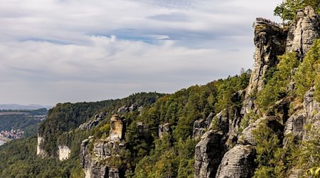 Numerous visitors stand on a viewing platform on the Bastei rock formation in the Saxon Switzerland National Park on German Unity Day / Photo: Frank Hammerschmidt/dpa