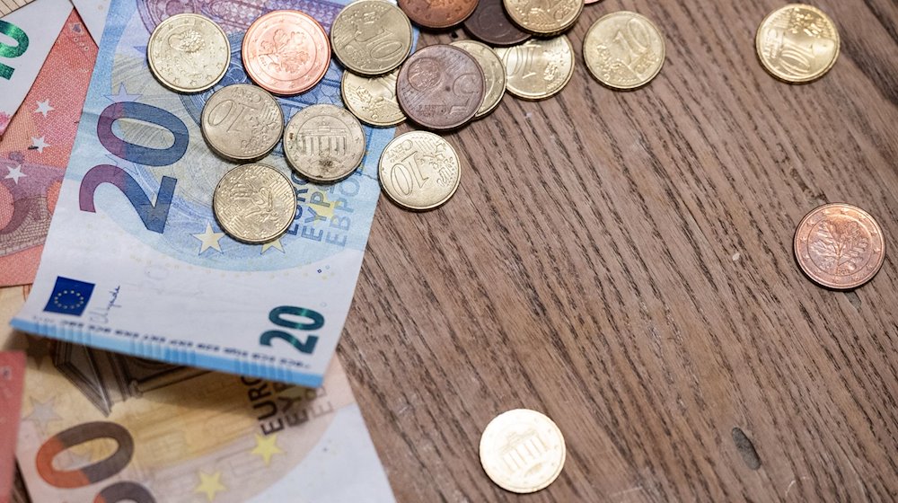 Billetes y monedas sobre una mesa / Foto: Hannes P Albert/dpa/Imagen simbólica