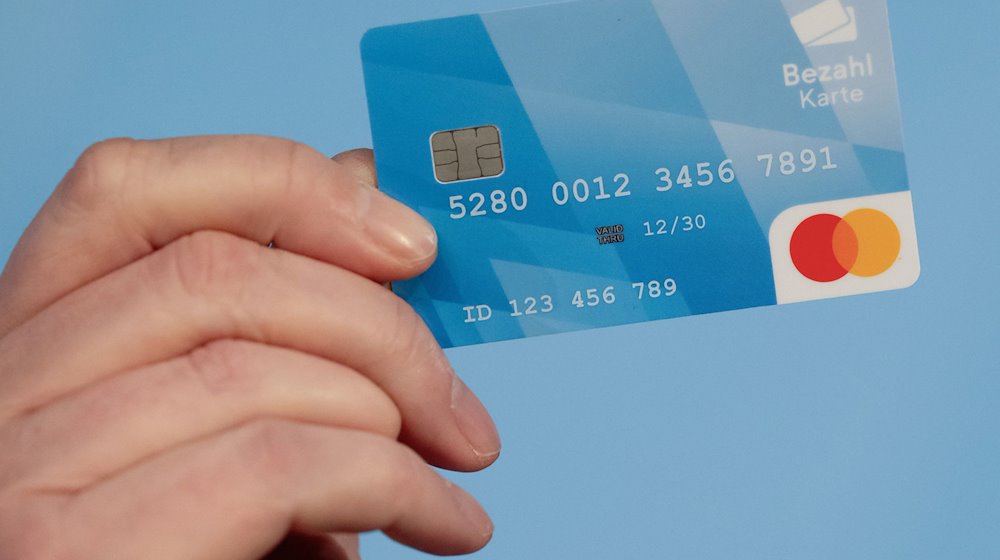 A man holds a payment card in his hand during a press conference / Photo: Sven Hoppe/dpa