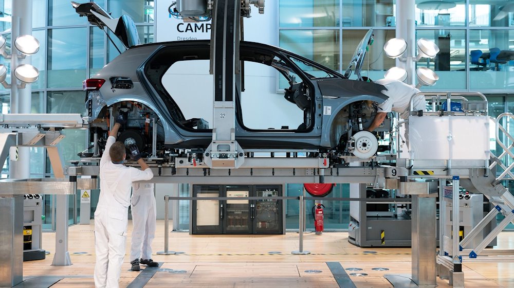 يقوم الموظفون في مصنع غليسيرنا لفولكس فاجن بتجميع هيكل السيارة ووحدة القيادة الخاصة بسيارة VW ID.3. / صورة: Sebastian Kahnert / dpa-Zentralbild / dpa