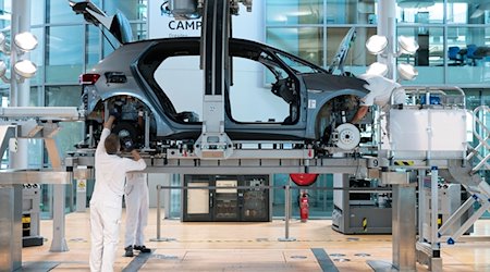 Empleados ensamblan la carrocería y la cadena cinemática de un VW ID.3 en la Fábrica Transparente de Volkswagen / Foto: Sebastian Kahnert/dpa-Zentralbild/dpa