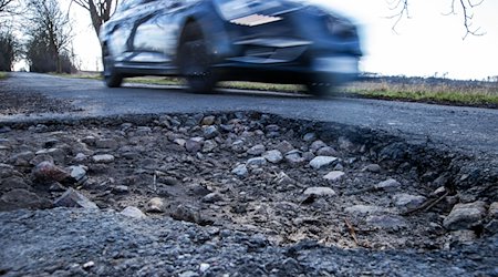 A car drives past a pothole. / Photo: Jens Büttner/dpa-Zentralbild/dpa/Symbolic image